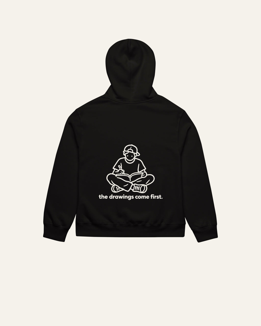 melowear the drawings come first hoodie, back print: a kid on the floor with a sketchbook, drawing